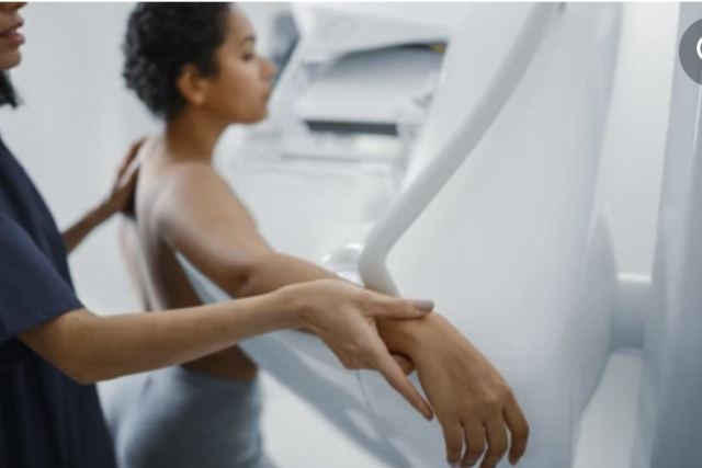 A technician is performing a mammography to a patient.
