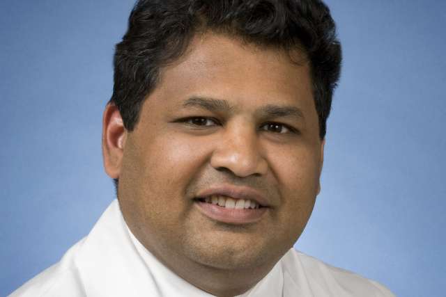 Raman Muthusamy, MD, MAS headshot wearing white coat and tie, smiling