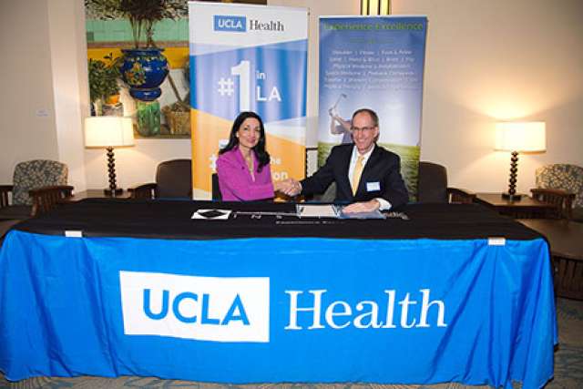 Johnese Spisso, president of UCLA Health and CEO of its hospital system, and Ronald Karzel, MD, managing general partner of the Southern California Orthopedic Institute, at a recent signing ceremony.