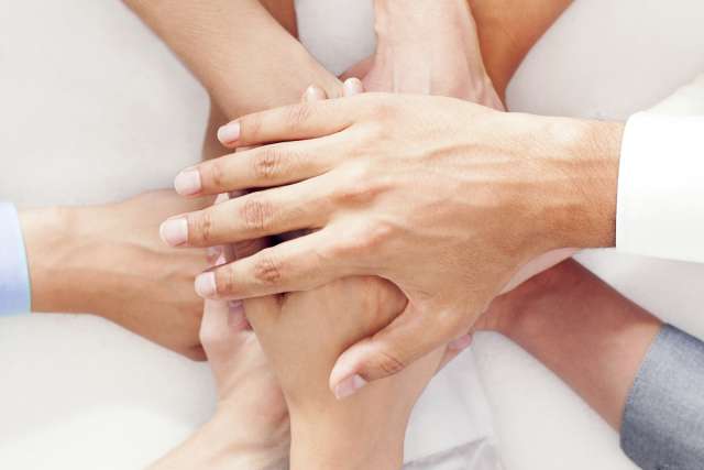 Doctors and patients putting hands together.