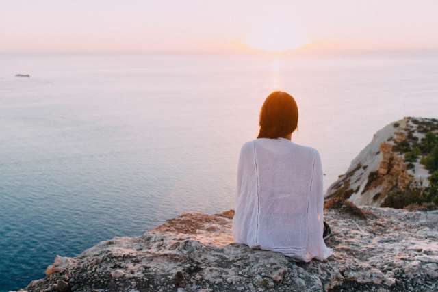 Woman seated at sunset