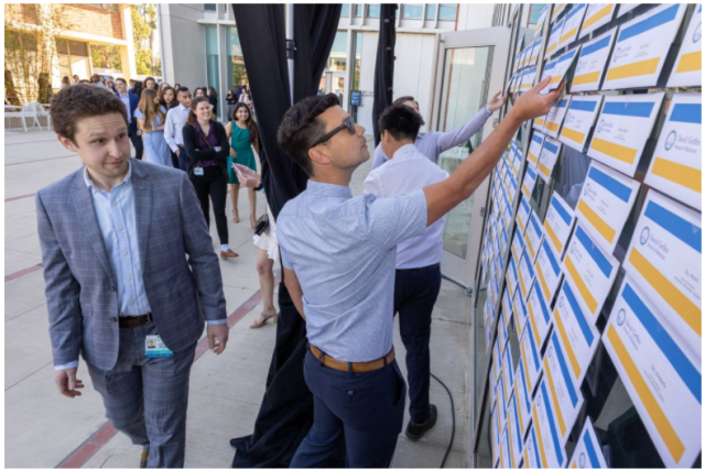 David Shabsovich, left, scans the wall for his name as David Okikawa reaches for his envelope.