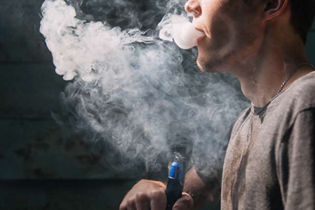 Man blowing smoke from e-cigarette