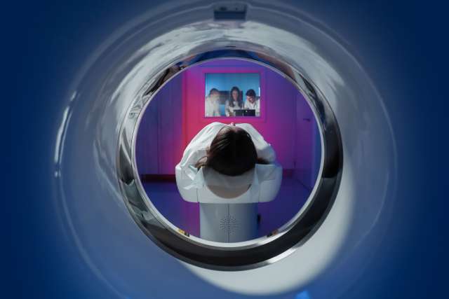 The girl patient is lying in the tomograph and waiting for a scan. 