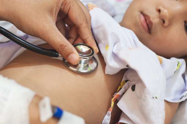 Doctor examining asian child girl and listen her lung and heart sound with stethoscope in the hospital