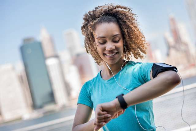 Woman runner checking sports watch
