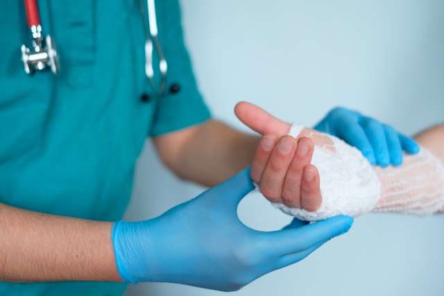 Physician bandaging a hand