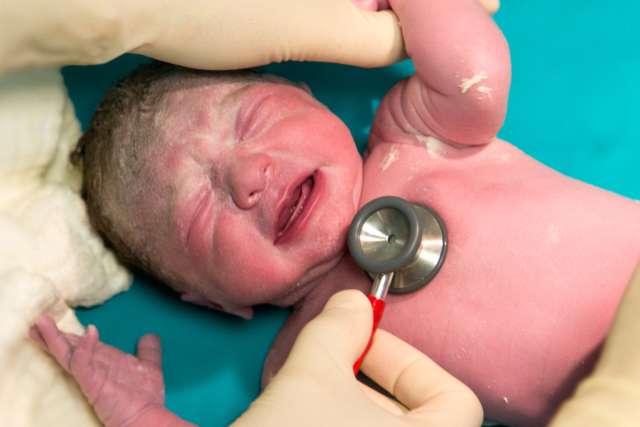 Doctor assessing newborn baby 
