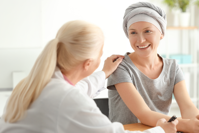 A doctor converses with a patient in a bright medical office.