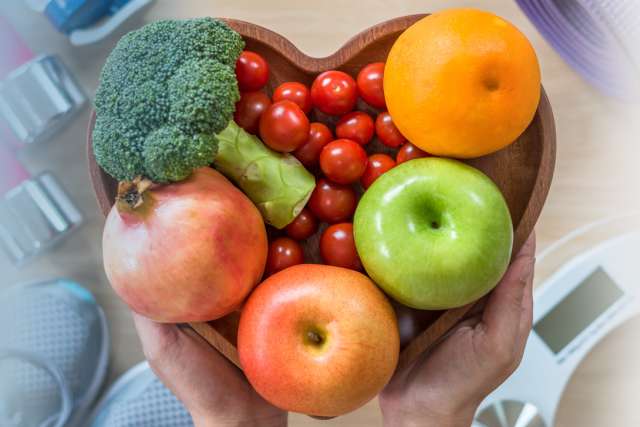 Healthy lifestyle concept, health diet in heart dish with exercise equipment, weight scale and sports shoes.