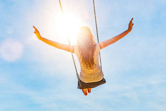 Woman on a swing with blue sky stock photo