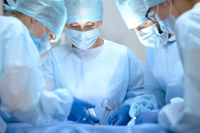 Surgical operating team performing thoracic surgery in modern hospital