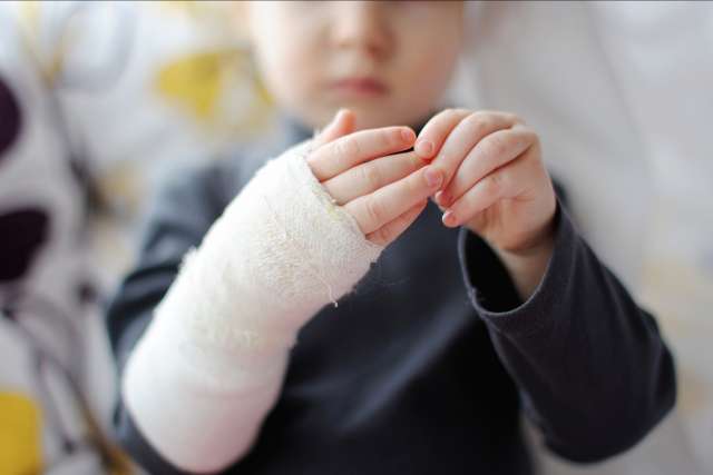 Little girl showing her bandaged hand