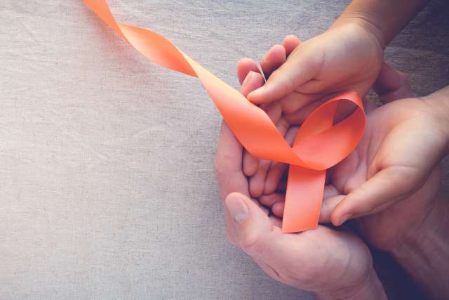 Adult and child hands holding orange Ribbons, Multiple sclerosis awareness,