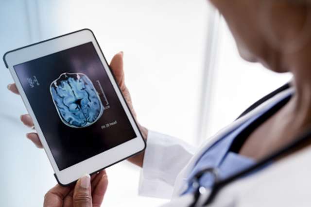 Doctor using tablet to view brain