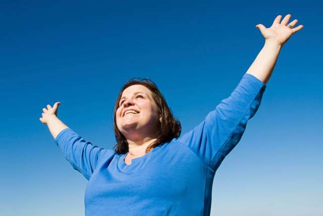Overweight woman celebrating outdoors