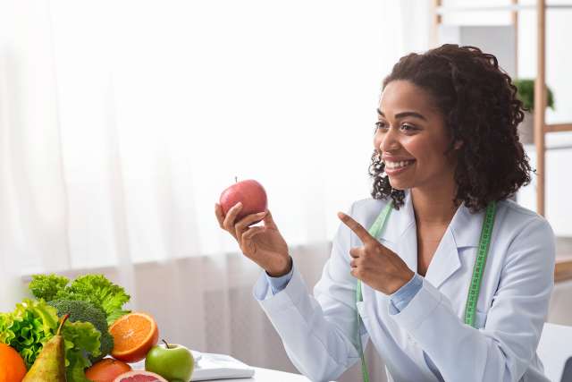 Nutritionist demonstrating value of fresh fruits and vegetables