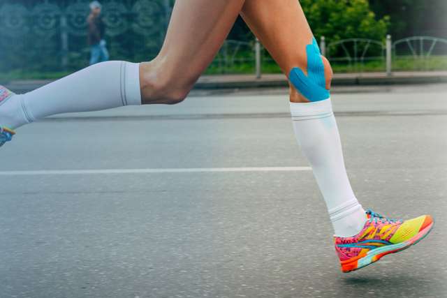 Knees in blue kinesiology taping during Siberian international marathon