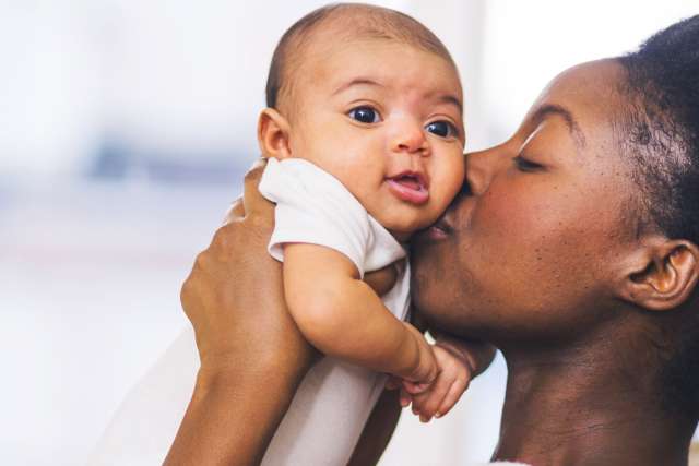 Mother kissing her infant