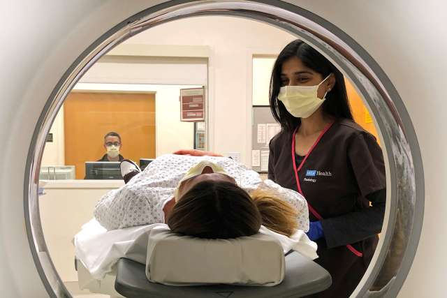 Woman patient with radiologist and scanner