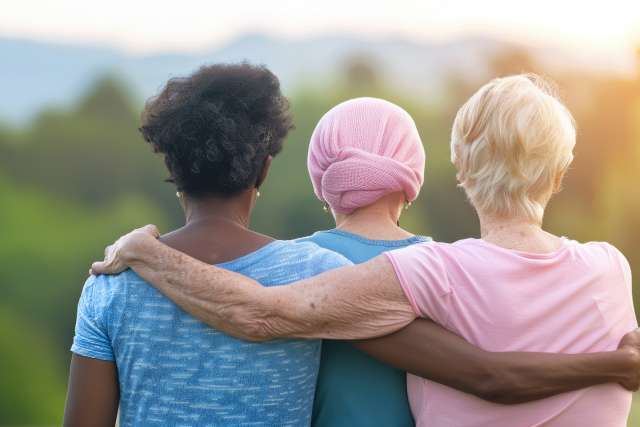 three women hugging watching sunset