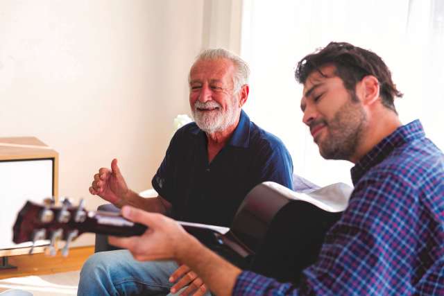 Guitarist playing music for senior