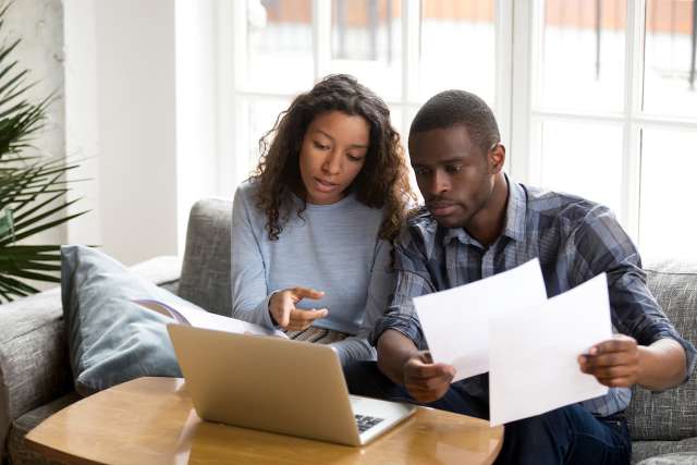 Couple at home looking for community resources on laptop