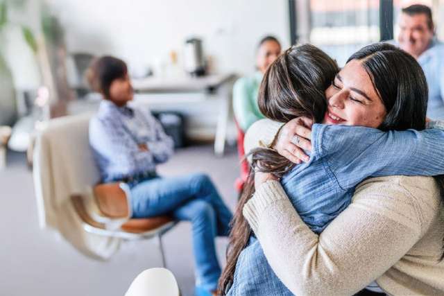 Two female cancer patients hug each other in support
