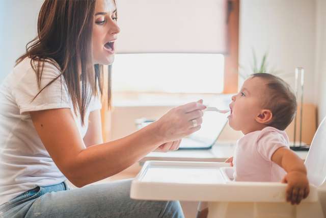Mother feeding young child