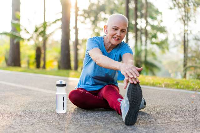 Woman cancer survivor exercising outdoors in a park