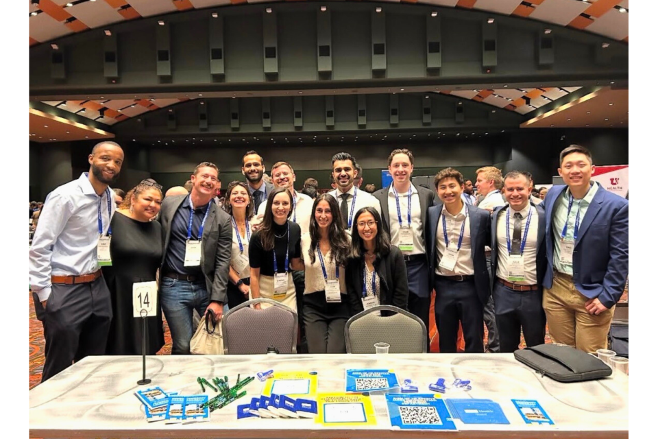 Group photo of a diverse team in a conference setting, smiling together.