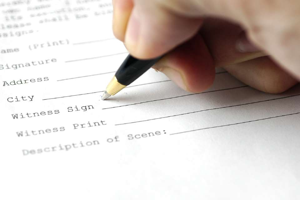 Person signing their name with a pen