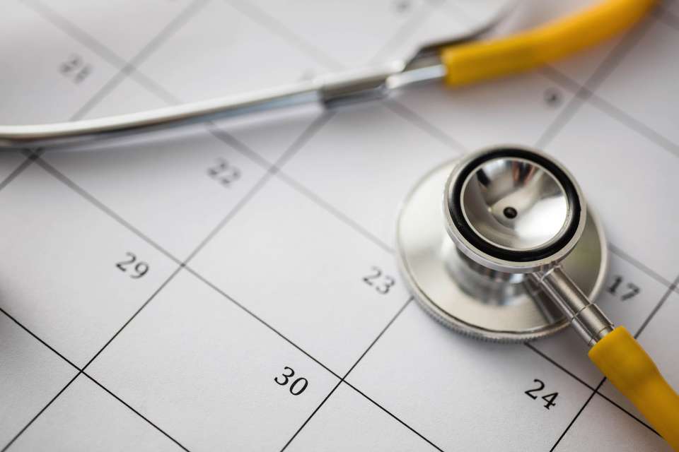 Closeup of a stethoscope resting on a calendar