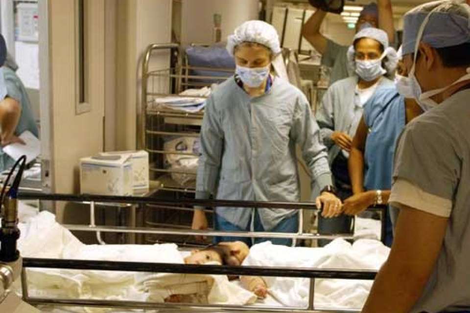 Doctor standing by twins' bedside