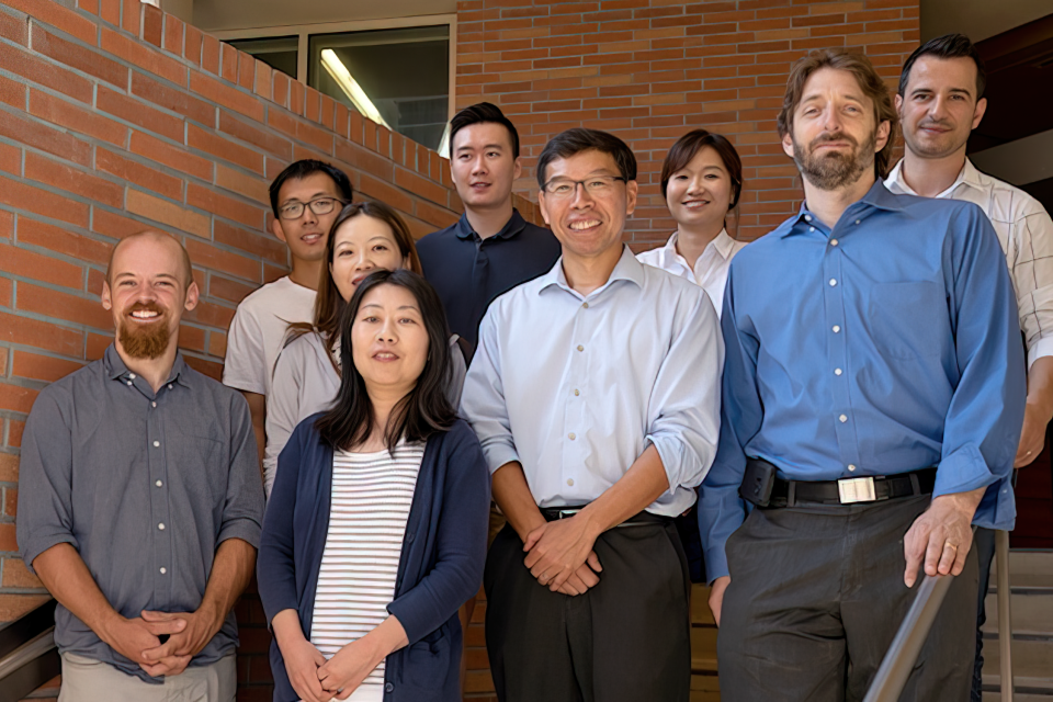 UCLA Jonsson Cancer Center Biostatistics, Analytical Support & Evaluation Shared Resource team members standing on a staircase in front of brick building