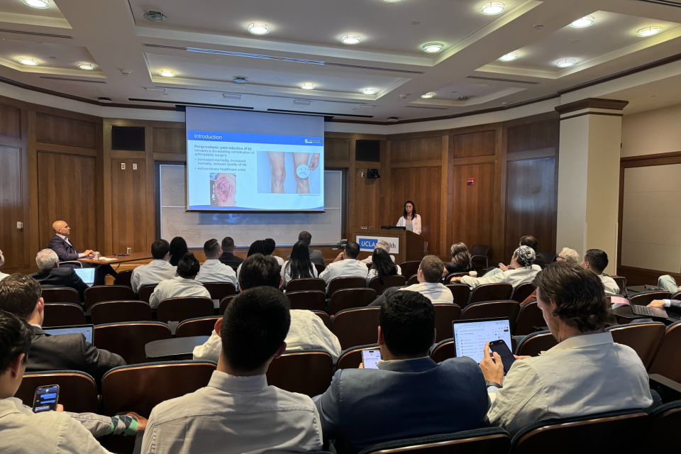 A group of residents sitting in a lecture hall listening to a lecture