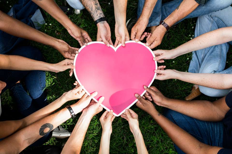People in a circle holding a heart