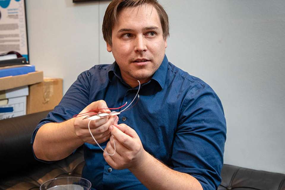 Jason Belling holding a prototype of a DNA device.