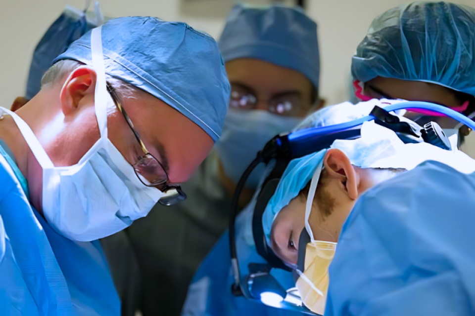 a group of doctors in the operating room performing general surgery