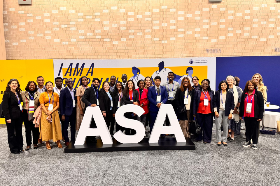 A diverse group of people pose behind large "ASA" at the 2024 ASA annual meeting 