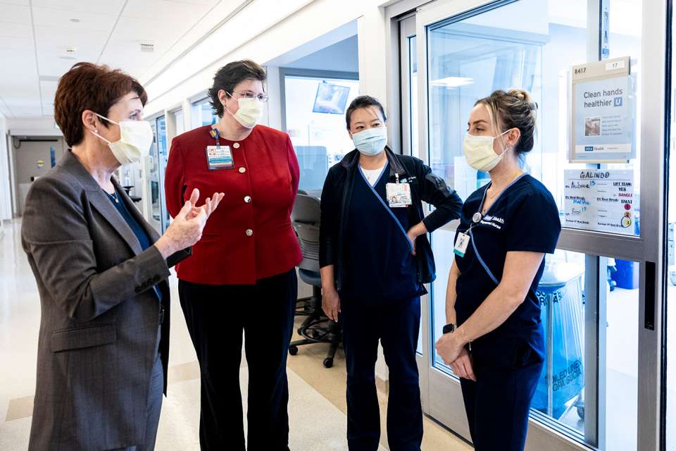 Karen Grimley speaking to three nurses in hallway