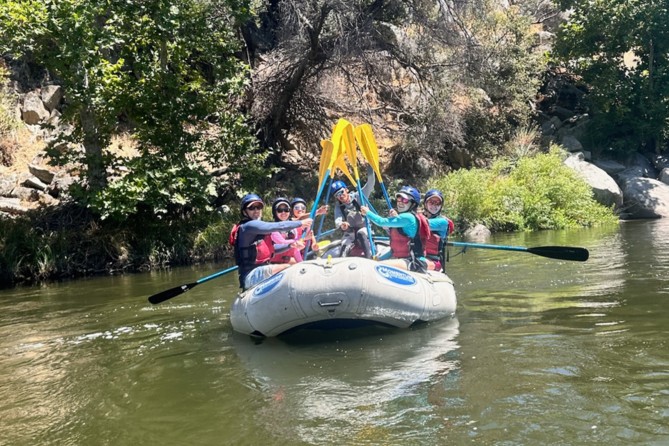 CRNAs hold paddles in a circle up together while rafting on the Kern River