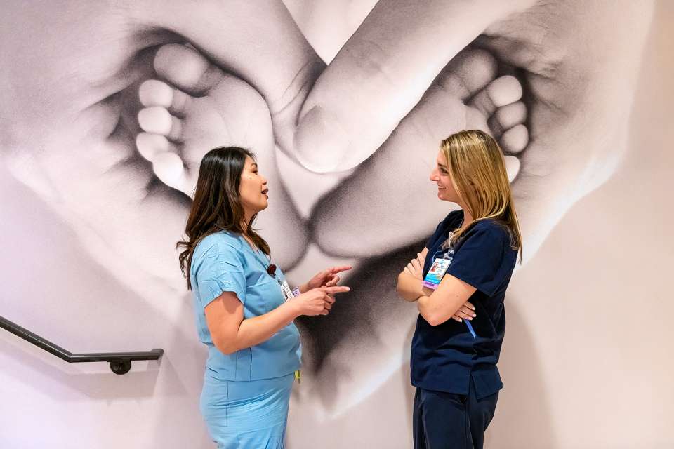 Nurses in front of photograph of baby