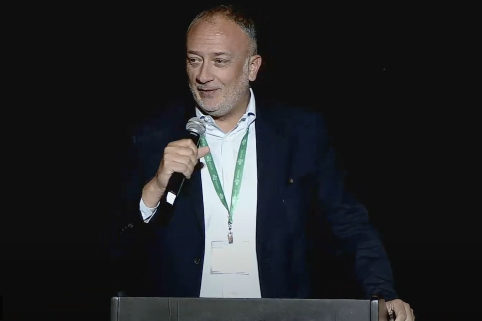 Dr. Maxime Cannesson standing at the podium holding a microphone during the 2023 Stoelting Conference.