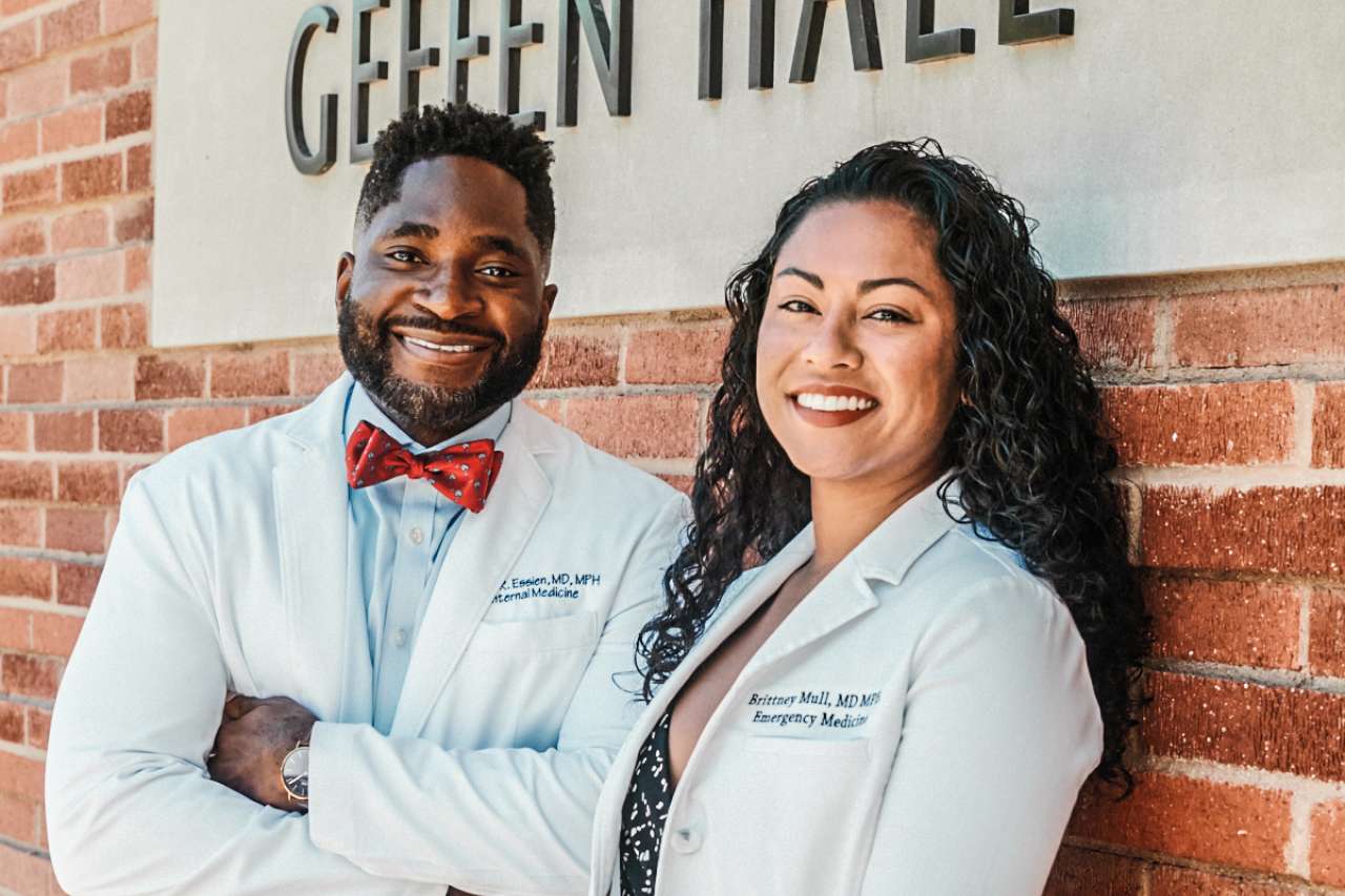 Utibe R. Essien, MD, MPH and Jessica P. Faiz, MD smiling in lab coats, outside of Geffen Hall