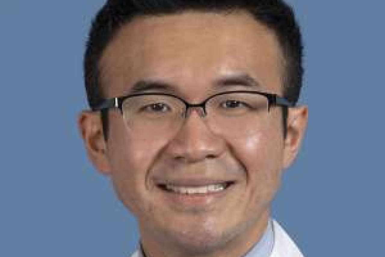 Medical professional in a white coat with a blue background.