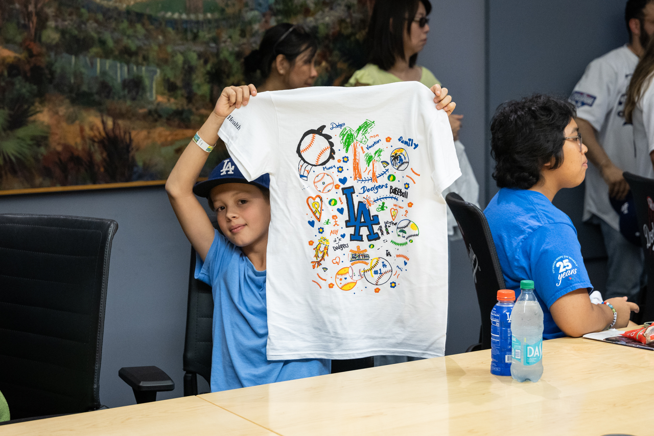 Bodhi Bennett holds up one of the T-shirts featuring a drawing from the art workshop. 
