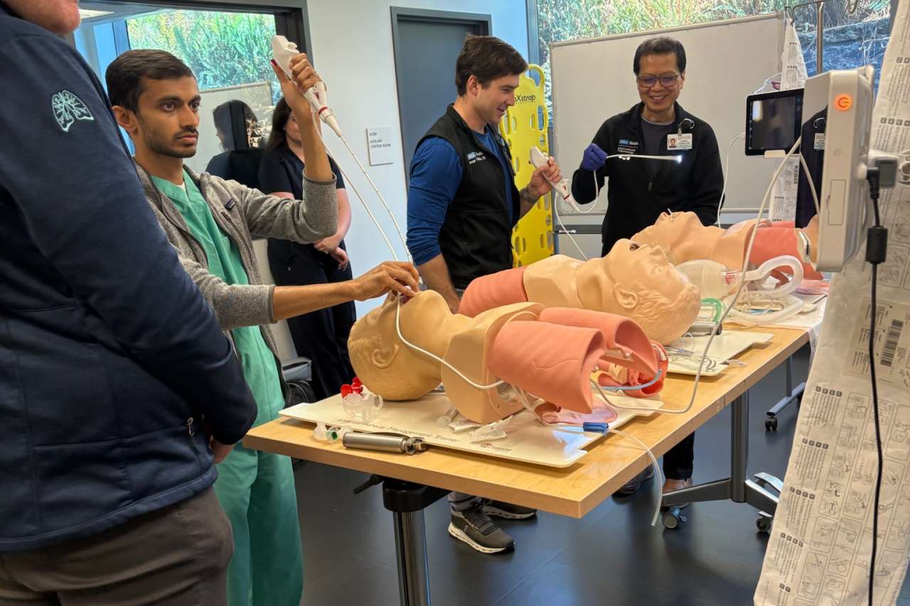 Pulmonary fellows practicing airway intubation on mannequins at a training table