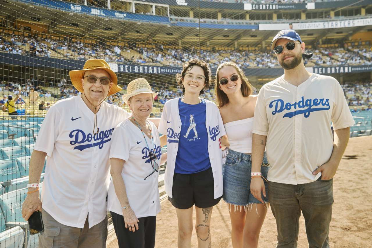 A family poses for a photo on the field at Dodger Stadium.