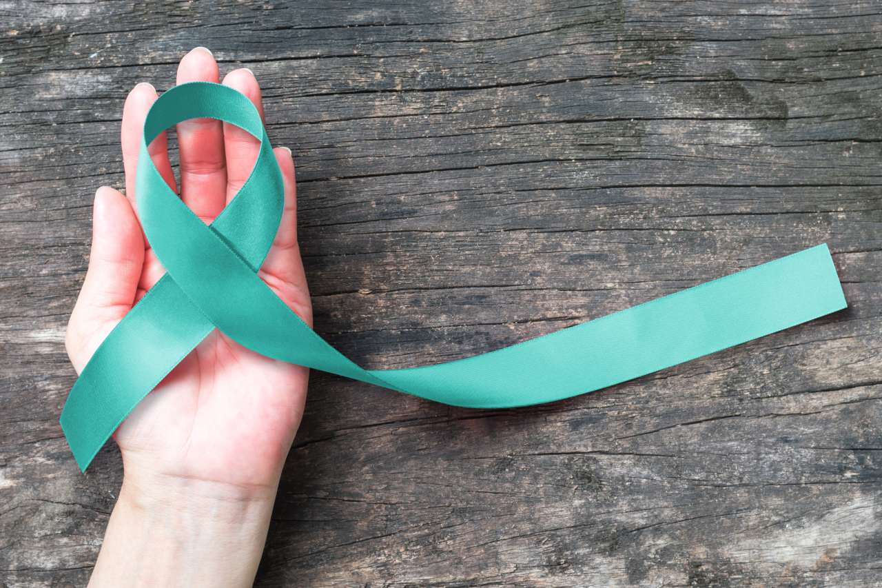 Hand holding gynecological cancer ribbon